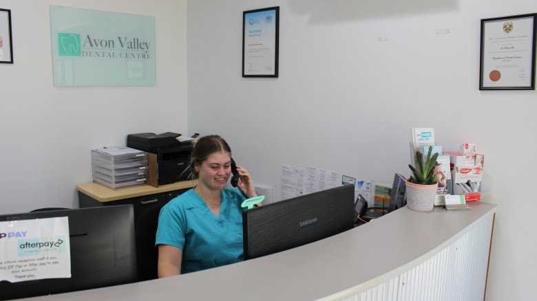 nurse answering the phone at avon valley dental centre's reception desk